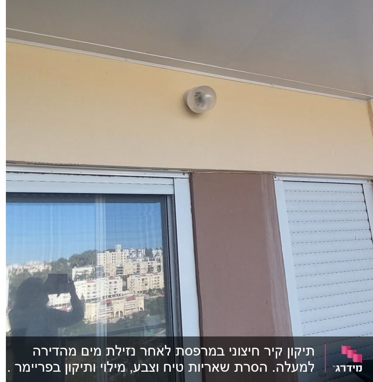 חלון זכוכית עם תריסים סגורים ומנורה על הקיר